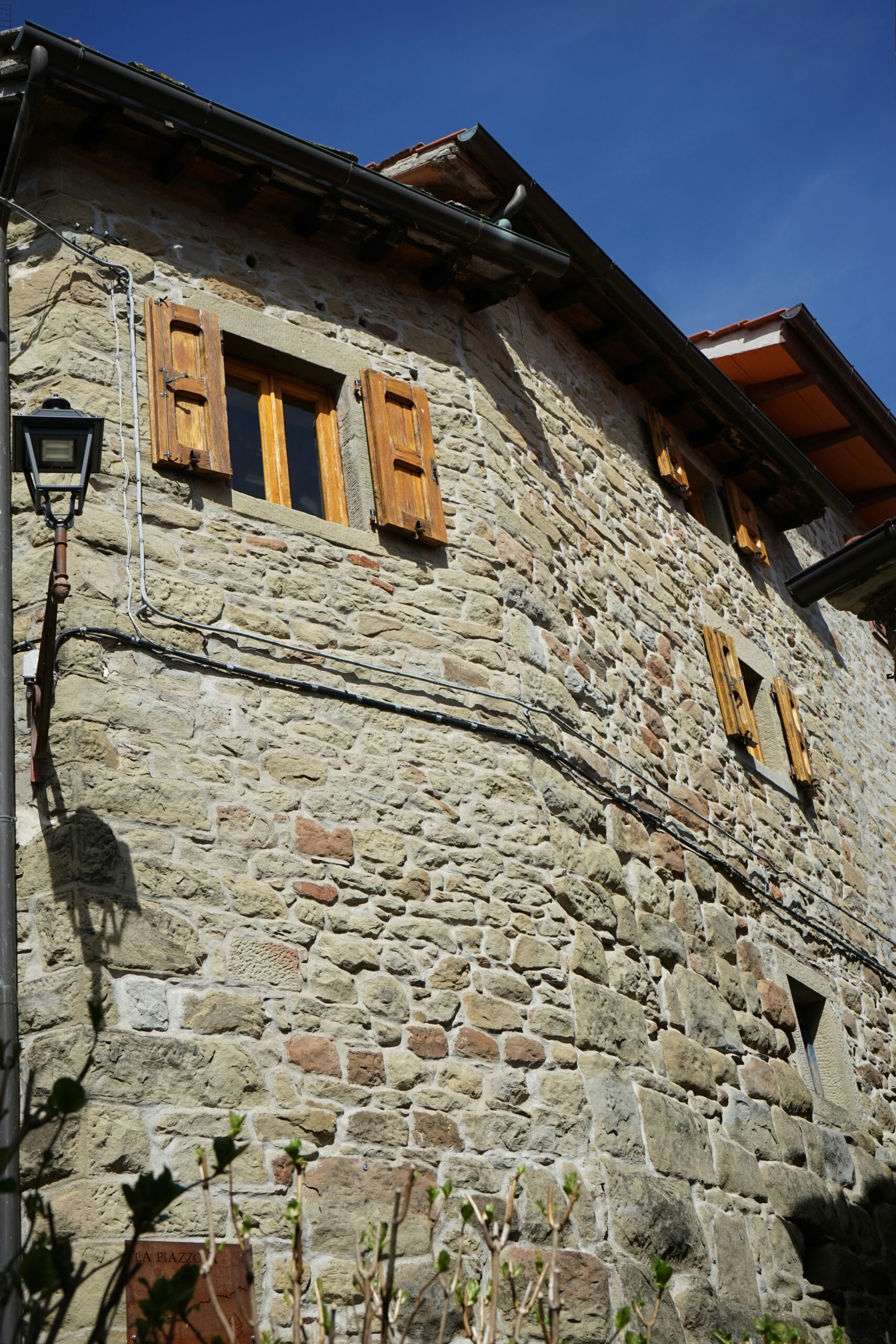 a stone building with wooden shutters and windows