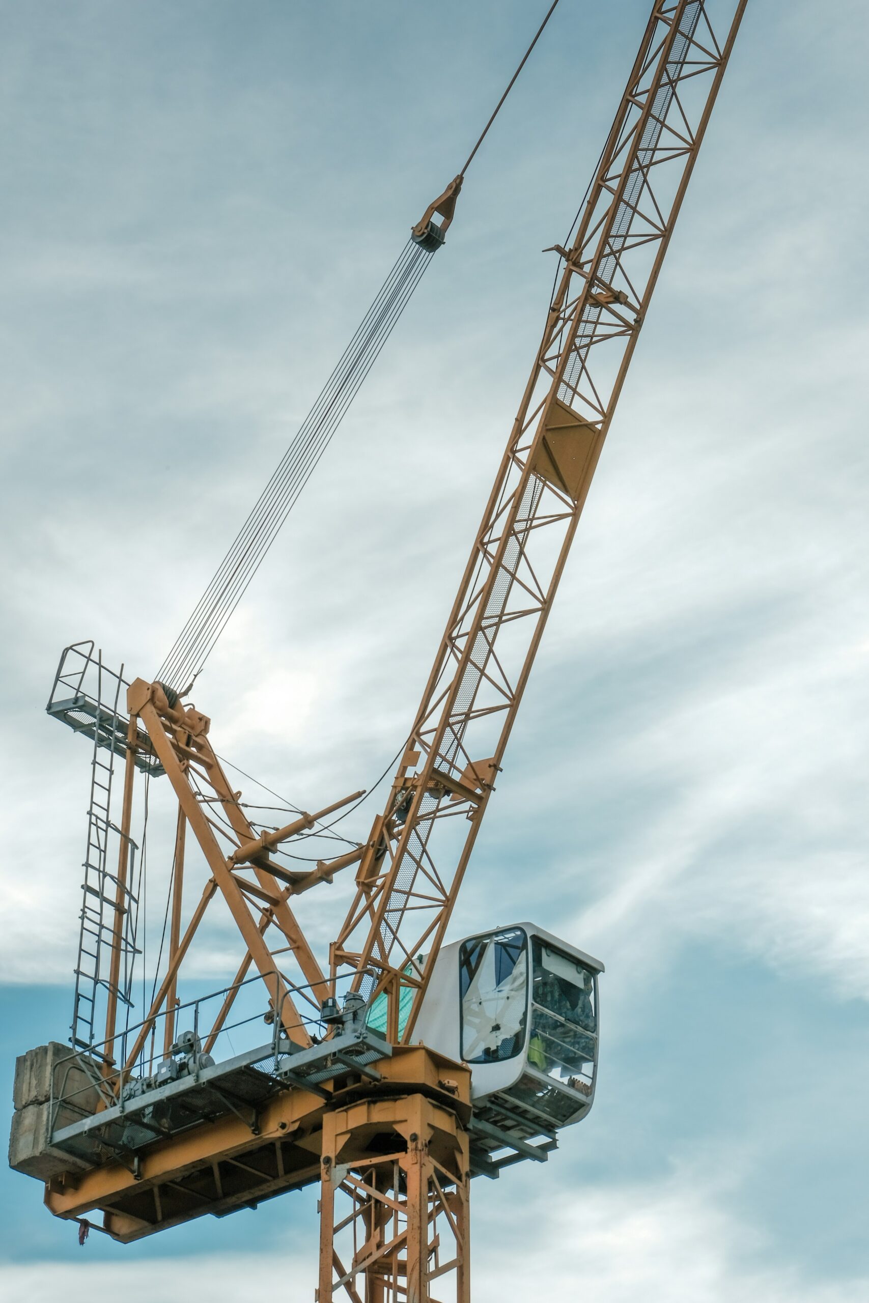 orange and gray crane under cloudy sky during daytime